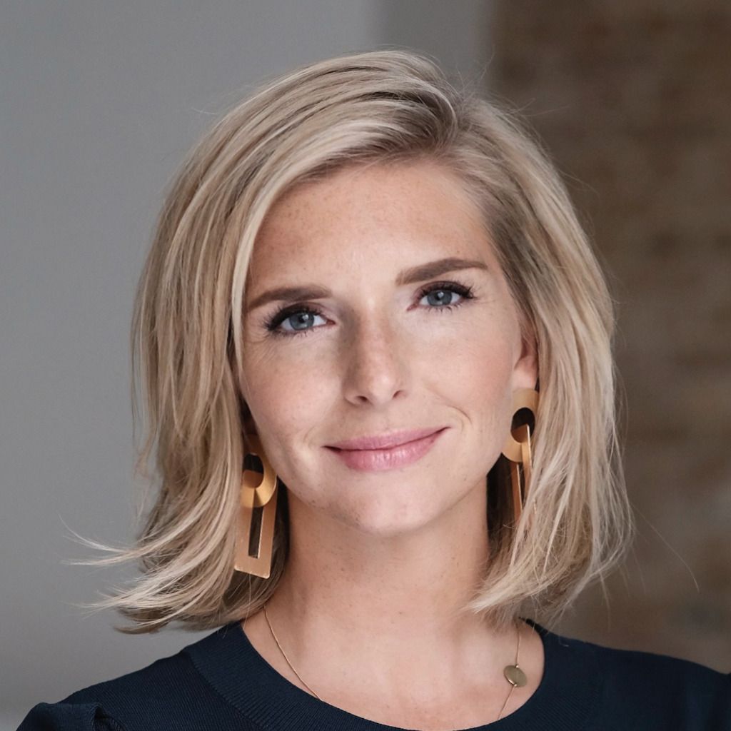 A blonde woman looking towards the camera