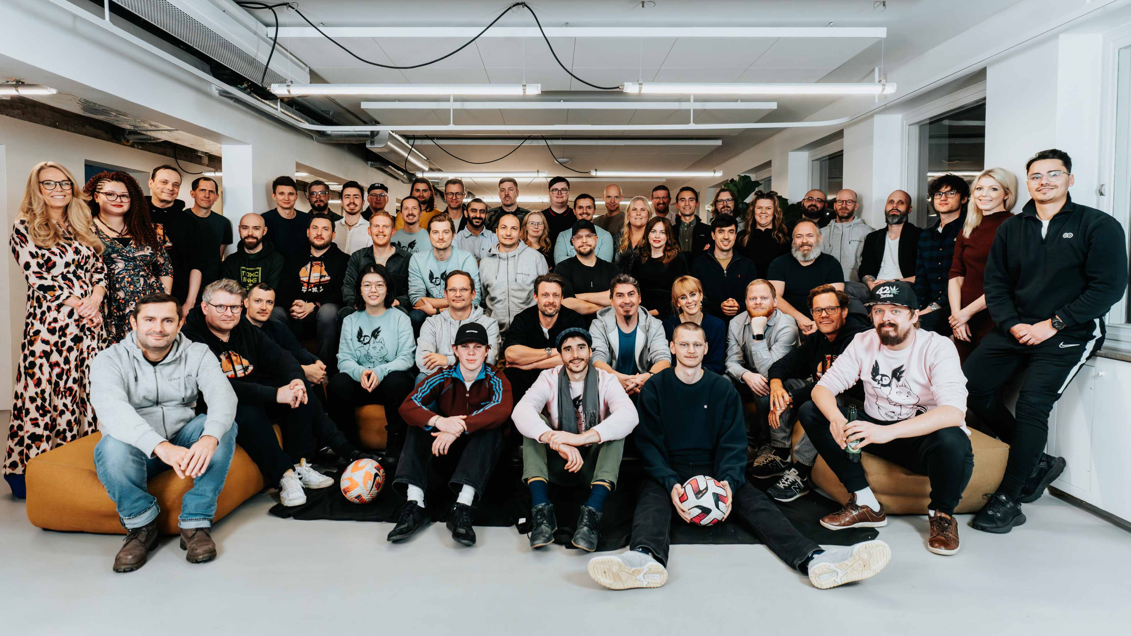 A large team of people posed in a room