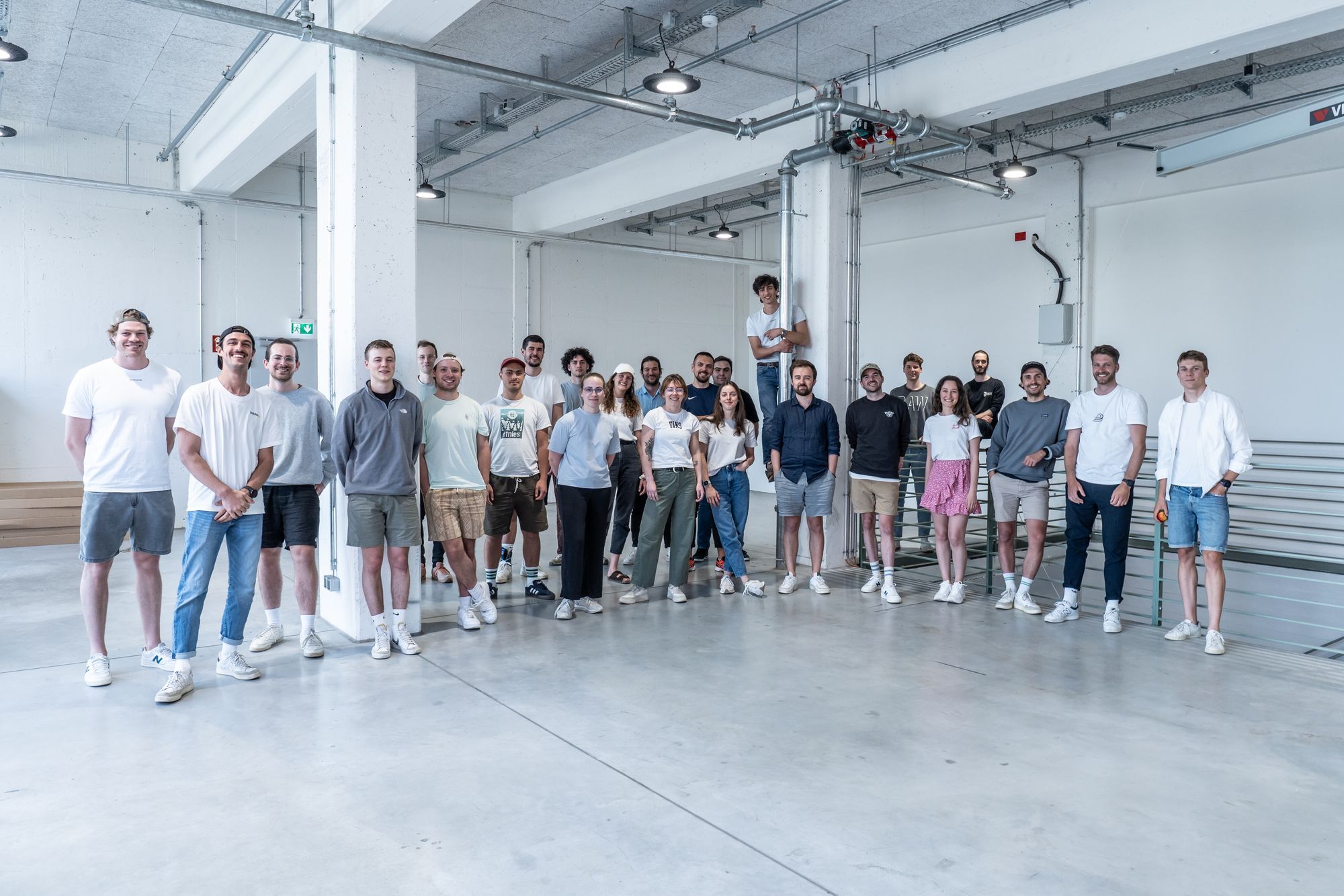 Happy large team of people posed in a warehouse