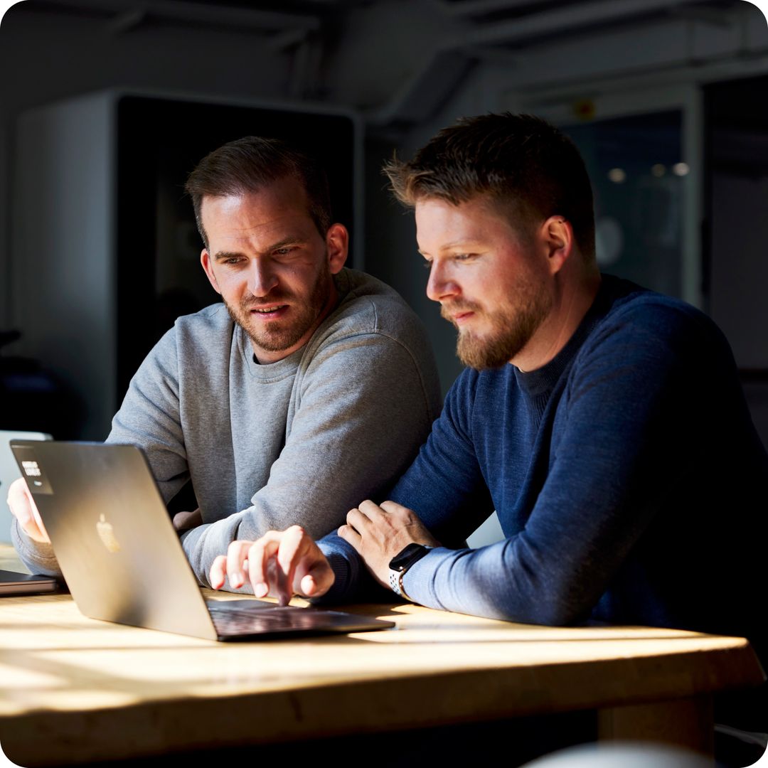 Two men looking at a laptop