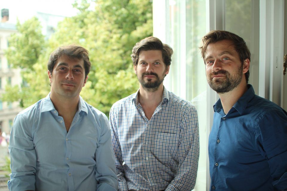 Three men standing in front of an open window